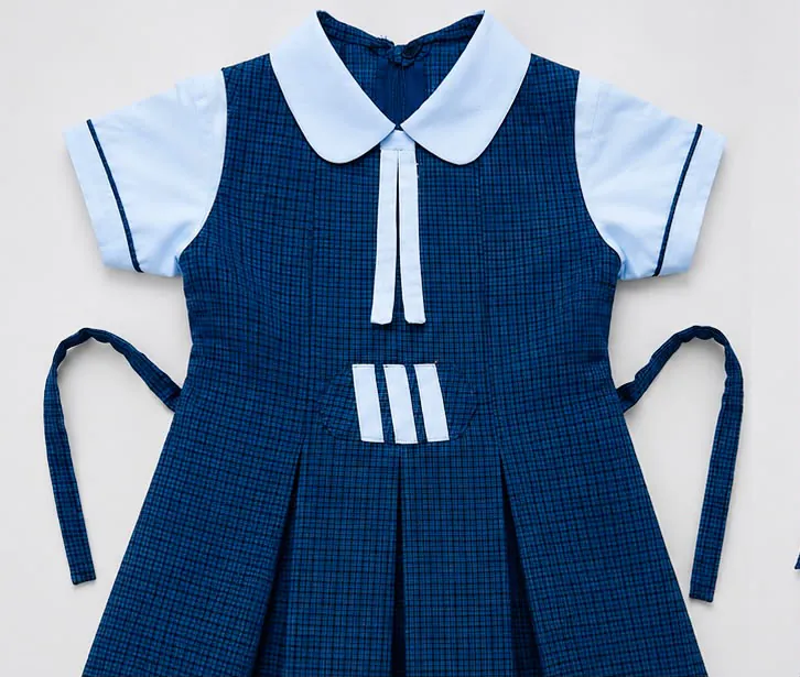 Blue checked school dress with white sleeves, a white collar and white front tabs