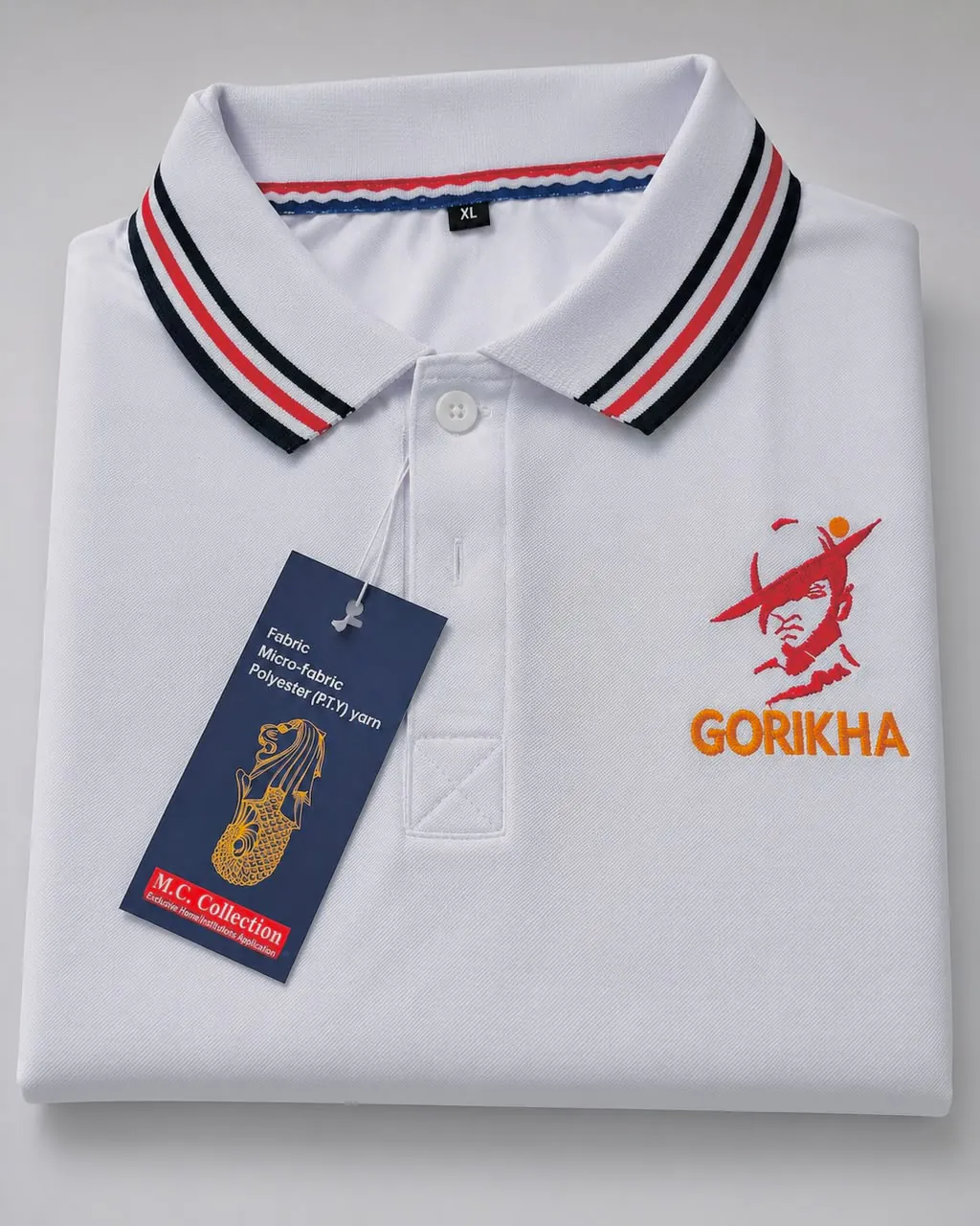 Folded white polo with a striped collar and an embroidered red-and-orange figure above the word GORIKHA